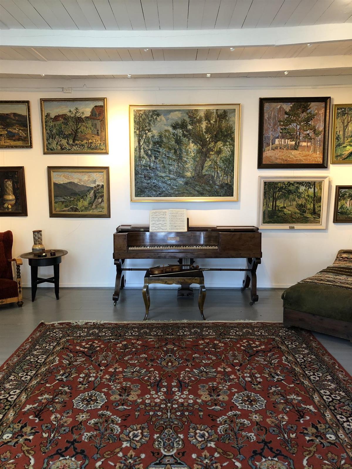 Rom i Førlands museum som inneholder gulvteppe, piano og vegg med kunst - Klikk for stort bilde